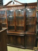 A good reproduction breakfront four door bookcase with central pull out slide, with leather gilt