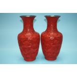 A pair of Cinnabar lacquered vases , decorated with flowers and panels of dragons. 38cm high