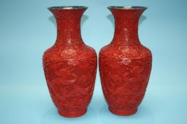 A pair of Cinnabar lacquered vases , decorated with flowers and panels of dragons. 38cm high