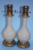 A pair of Chinese Celadon porcelain table oil lamps, with brass mounts. 40cm high