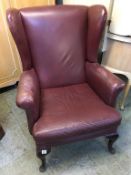 A burgundy Wing armchair. Provenance: Used in the Alan Bennett film 'Dinner at Noon'