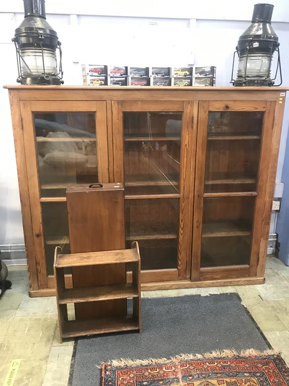An early 20th century pine three door glazed school cabinet, with three fitted shelves, 185cm