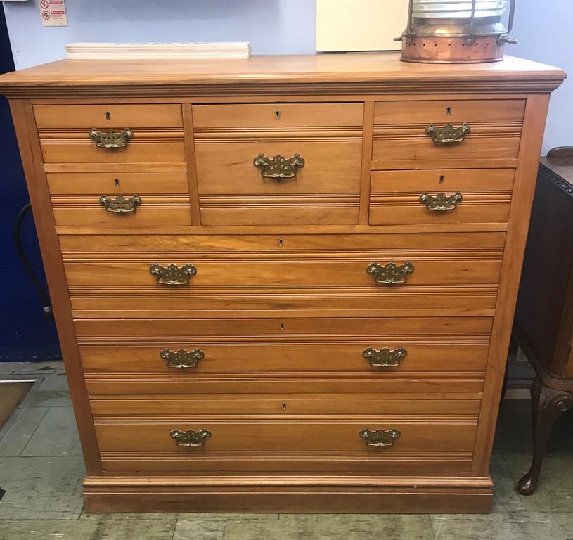 An Edwardian chest of drawers with central deep drawer, flanked by two short drawers, below three