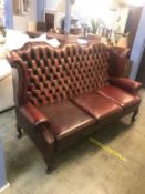 An oxblood Chesterfield high back three seater settee