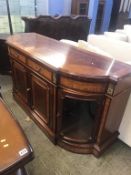 A Charles Barr bow front sideboard, with convex glass doors to each end, with two central drawers