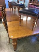 A large oak extending dining table, with three extra leaves and a set of six Edwardian carved oak