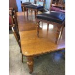 A large oak extending dining table, with three extra leaves and a set of six Edwardian carved oak