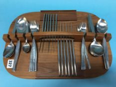 A quantity of stainless steel cutlery on a tea caddy