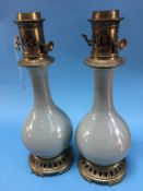 A pair of Chinese Celadon porcelain oil lamps, with brass mounts