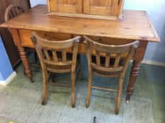 A pine table, with two drawers and three chairs