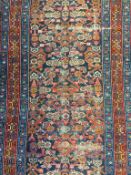 A 1930’s Hamadan Persian runner, the blue ground with geometric floral medallions in orange, red and