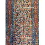 A 1930’s Hamadan Persian runner, the blue ground with geometric floral medallions in orange, red and