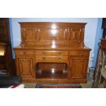 A large oak sideboard, with panelled and raised back, below a central recess, drawers and cupboard
