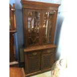 An Edwardian oak bookcase, with glazed doors, below two short drawers and two panelled doors