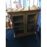 A small pine two door glazed wall cabinet