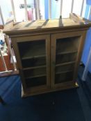 A small pine two door glazed wall cabinet