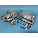 Two plated tureens and a set of salad servers
