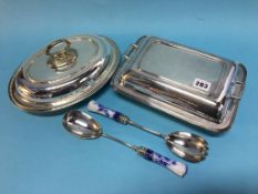 Two plated tureens and a set of salad servers