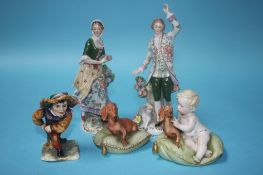 A pair of Continental porcelain figures, a Capo Di Monte soldier and two dogs seated on a cushion (