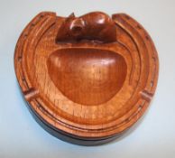 A Robert Mouseman Thompson dark oak horse shoe ashtray, with carved mouse