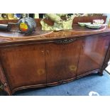 A large modern three door serpentine front buffet sideboard