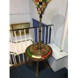 A painted circular tripod table and a modern lamp