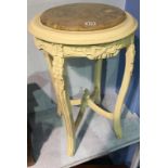 A cream pedestal with marble top