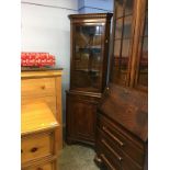 A reproduction mahogany corner cabinet