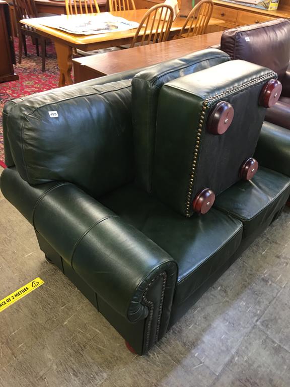 A green leather two seater settee and a stool