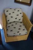 A wicker work armchair, with dog patterned cushions
