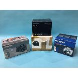 Four boxed digital cameras including Olympus, Pana