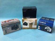 Four boxed digital cameras including Olympus, Pana