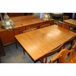 A teak sideboard and a teak extending dining table with four chairs