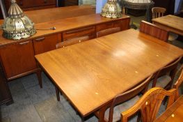 A teak sideboard and a teak extending dining table with four chairs