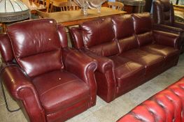 A burgundy leather three seater settee and a recliner