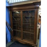 A large oak bookcase with moulded cornice, two glazed doors, supported on cabriole legs, 161cm wide,