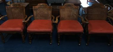 A set of four walnut carver chairs, with bergère backs and upholstered seats