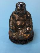 Gilt metal Buddha, on carved hardwood stand