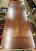 A long narrow mahogany dining table, with sewing machine ends