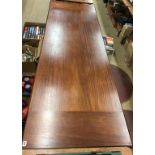 A long narrow mahogany dining table, with sewing machine ends