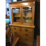 An oak chest of drawers with bookcase top