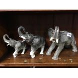 A group of three graduated ceramic elephants