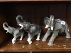 A group of three graduated ceramic elephants