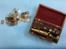 A brass field microscope and various lenses, in fitted mahogany case