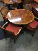 A walnut circular dining table, with four bergère armchairs