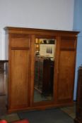 A mahogany triple door wardrobe with dental cornice and central mirror door, 183cm wide x 210 height