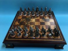 A metalwork chess set and chess board with Elizabethan design military figures. Contactless