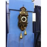 A wall clock with brass weights