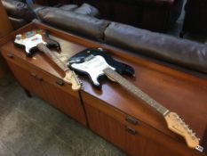 A Squire Stratocaster and a Burswood electric guitar