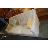A cream three seater settee (feet to be unpacked)